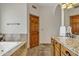 Bathroom featuring granite counters, sink, wood cabinets, tub and wood door at 4222 E Brown Rd # 31, Mesa, AZ 85205