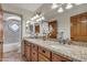 Bathroom featuring granite countertops, double sinks, wood cabinets, and decorative tile in the shower at 4222 E Brown Rd # 31, Mesa, AZ 85205