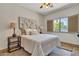 Bedroom featuring cozy bed, side tables, lamps, shutters, and bright windows at 4222 E Brown Rd # 31, Mesa, AZ 85205
