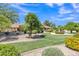 Home exterior featuring an expertly landscaped front yard with mature trees, shrubs, and a vibrant flower bed at 4222 E Brown Rd # 31, Mesa, AZ 85205