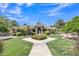Charming home featuring a lush front yard with manicured lawn, mature trees, and a decorative fountain at 4222 E Brown Rd # 31, Mesa, AZ 85205