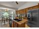 Kitchen featuring a center island with sink, granite countertops, and stainless steel refrigerator at 4222 E Brown Rd # 31, Mesa, AZ 85205