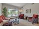 Bright living room showcasing large windows with backyard views and rustic furniture with red accents at 4222 E Brown Rd # 31, Mesa, AZ 85205