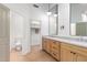 Modern bathroom with double vanity, large mirror, and light wood cabinets at 11568 E Whispering Wind Dr, Scottsdale, AZ 85255