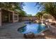 Relaxing backyard with a kidney-shaped pool, flagstone patio, and mature desert landscaping at 11568 E Whispering Wind Dr, Scottsdale, AZ 85255