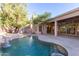 Inviting backyard oasis featuring a sparkling pool, expansive patio, and lush landscaping at 11568 E Whispering Wind Dr, Scottsdale, AZ 85255
