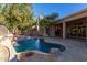 Stunning pool and patio area with a spacious layout, water feature, and mature trees at 11568 E Whispering Wind Dr, Scottsdale, AZ 85255