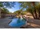Peaceful backyard retreat with a kidney-shaped pool, fire pit, and mature landscaping at 11568 E Whispering Wind Dr, Scottsdale, AZ 85255