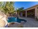 Resort-style backyard with a beautiful pool, expansive patio, and lush landscaping at 11568 E Whispering Wind Dr, Scottsdale, AZ 85255