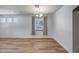 Well-lit living area with hardwood floors, a hanging light fixture, and large windows, ideal for gatherings at 4512 W Stoneman Dr, Anthem, AZ 85086