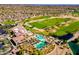 Aerial view of community with a golf course, pool, and clubhouse surrounded by houses and lush greenery at 19926 N Organ Pipe Dr, Surprise, AZ 85374