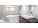 Charming bathroom with soaking tub, vintage-style vanity, and hexagon tile flooring at 38 W Lynwood St, Phoenix, AZ 85003