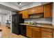 Practical kitchen with wood cabinets, granite countertops, and stainless steel sink at 9445 N 94Th Pl # 102, Scottsdale, AZ 85258