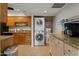 Bright laundry area featuring stacked washer and dryer, granite countertops, ample storage, and water heater at 9445 N 94Th Pl # 102, Scottsdale, AZ 85258