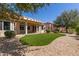 Well-maintained backyard featuring a covered patio, artificial turf and mature trees at 13335 W Broken Arrow Dr, Sun City West, AZ 85375