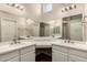 Bathroom featuring dual sinks with white cabinets and a large mirror at 13335 W Broken Arrow Dr, Sun City West, AZ 85375