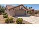 Attached garage in a desert-landscaped yard with a flag and a decorative niche over the closed garage door at 13335 W Broken Arrow Dr, Sun City West, AZ 85375