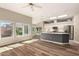 Open-concept living space with wood floors that flows into a modern kitchen area at 13335 W Broken Arrow Dr, Sun City West, AZ 85375