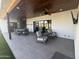 Open patio with seating areas and dining table, complemented by a ceiling fan and television, perfect for entertaining at 7544 E Mckinley St, Scottsdale, AZ 85257