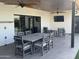 Covered patio featuring a spacious dining table, seating, ceiling fans, and outdoor entertainment setup at 7544 E Mckinley St, Scottsdale, AZ 85257