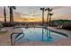 Community pool featuring a sunset view, palm trees, lounge chairs, and serene desert mountain views at 10401 N Saguaro Blvd # 224, Fountain Hills, AZ 85268