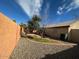 View of the backyard featuring gravel landscaping, a block wall fence, and green grass at 3202 E Decatur St, Mesa, AZ 85213