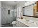 Modern bathroom featuring tiled shower with glass door, white vanity, and soft lighting at 3202 E Decatur St, Mesa, AZ 85213