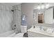 Modern bathroom featuring white and gray decorative tiling and a bathtub/shower combination at 3202 E Decatur St, Mesa, AZ 85213