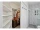 Well-organized walk-in closet with built-in shelves and clothing racks, adjacent to bathroom at 3202 E Decatur St, Mesa, AZ 85213