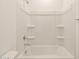 Full white bathtub and shower combo with tiled walls in a bright bathroom at 3451 E Alexander Dr, San Tan Valley, AZ 85143