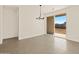 Open dining area with tile floors, modern chandelier, and sliding glass door to backyard at 3451 E Alexander Dr, San Tan Valley, AZ 85143
