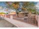 Ranch style home with a spacious front yard and a red metal fence at 821 E Roeser Rd, Phoenix, AZ 85040