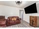 Living room with brown couches, large TV, and wood floors at 821 E Roeser Rd, Phoenix, AZ 85040