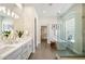 Bright bathroom featuring double sinks, walk-in shower, soaking tub and walk-in closet at 34599 N 99Th Way, Scottsdale, AZ 85262