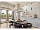 Dining area with modern lighting fixture and backyard views, situated next to the gourmet kitchen at 34599 N 99Th Way, Scottsdale, AZ 85262