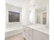 Main bathroom with double vanity, soaking tub, and large mirror at 36933 W La Paz St, Maricopa, AZ 85138
