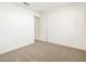 Bright bedroom with carpeted floor and door to bathroom at 36933 W La Paz St, Maricopa, AZ 85138