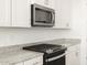 Modern kitchen features stainless steel appliances and white cabinets at 36933 W La Paz St, Maricopa, AZ 85138