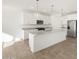 Modern kitchen with white cabinets, granite countertops and island at 36933 W La Paz St, Maricopa, AZ 85138