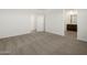 Spacious carpeted bedroom with white walls and view into ensuite bathroom at 36944 W Prado St, Maricopa, AZ 85138