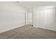 This bedroom includes a closet and a door and plush neutral carpeting at 36944 W Prado St, Maricopa, AZ 85138