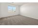 A carpeted bedroom with a window lets in natural sunlight at 36944 W Prado St, Maricopa, AZ 85138