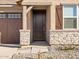 A charming front entrance featuring a decorative wood door and stone facade at 36944 W Prado St, Maricopa, AZ 85138