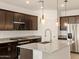 Kitchen featuring granite countertops, dark wood cabinets and stainless steel appliances at 36944 W Prado St, Maricopa, AZ 85138