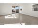 Bright, spacious living room featuring tile floors, a large sliding glass door and windows at 36944 W Prado St, Maricopa, AZ 85138