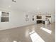 Open-concept living room with ceramic tile flooring next to kitchen at 36944 W Prado St, Maricopa, AZ 85138