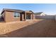 Tan house exterior with covered patio and backyard at 36973 W La Paz St, Maricopa, AZ 85138