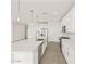 Spacious kitchen with white cabinets, island, and quartz countertops at 36973 W La Paz St, Maricopa, AZ 85138