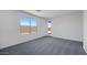Inviting bedroom featuring soft carpeting, ample natural light from large windows, and a private exterior door at 17134 W Hackamore Dr, Surprise, AZ 85387