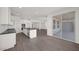 Modern kitchen with an island, stainless steel appliances, and a view of the connecting living space with hardwood floors at 17134 W Hackamore Dr, Surprise, AZ 85387